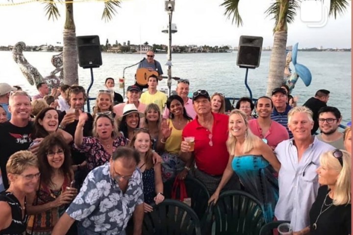 a group of people posing in front of a body of water
