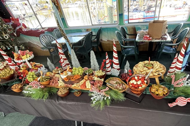 Festive table with assorted fruits, nuts, and decorations for a holiday gathering.