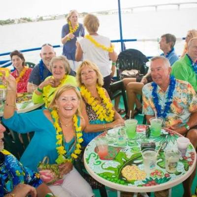 a group of people sitting at a table with a birthday cake