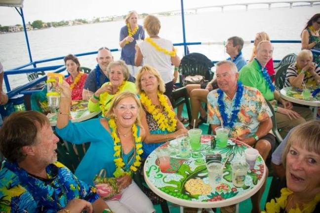 a group of people sitting at a table with a birthday cake