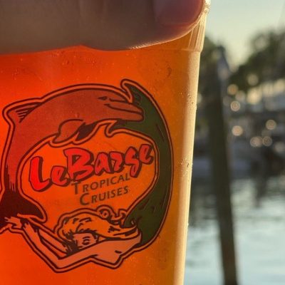 a glass of orange juice next to a cup of beer